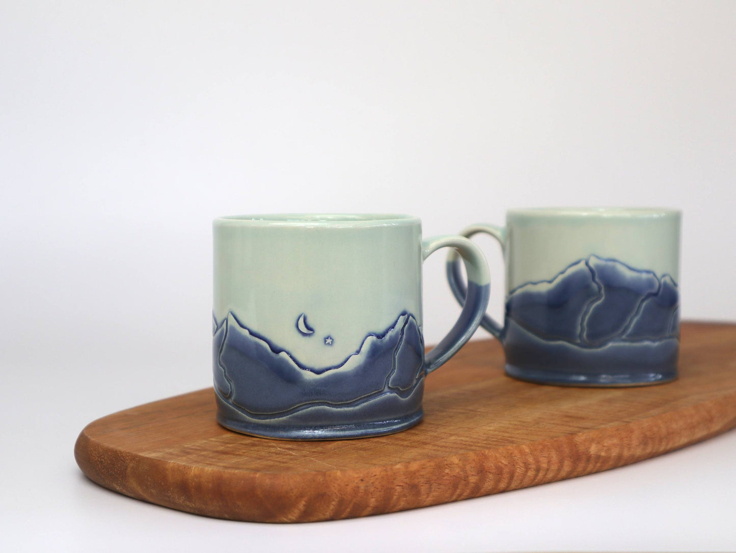 Set of two Handmade Mountain Range Mugs with unique moon and mountain designs.