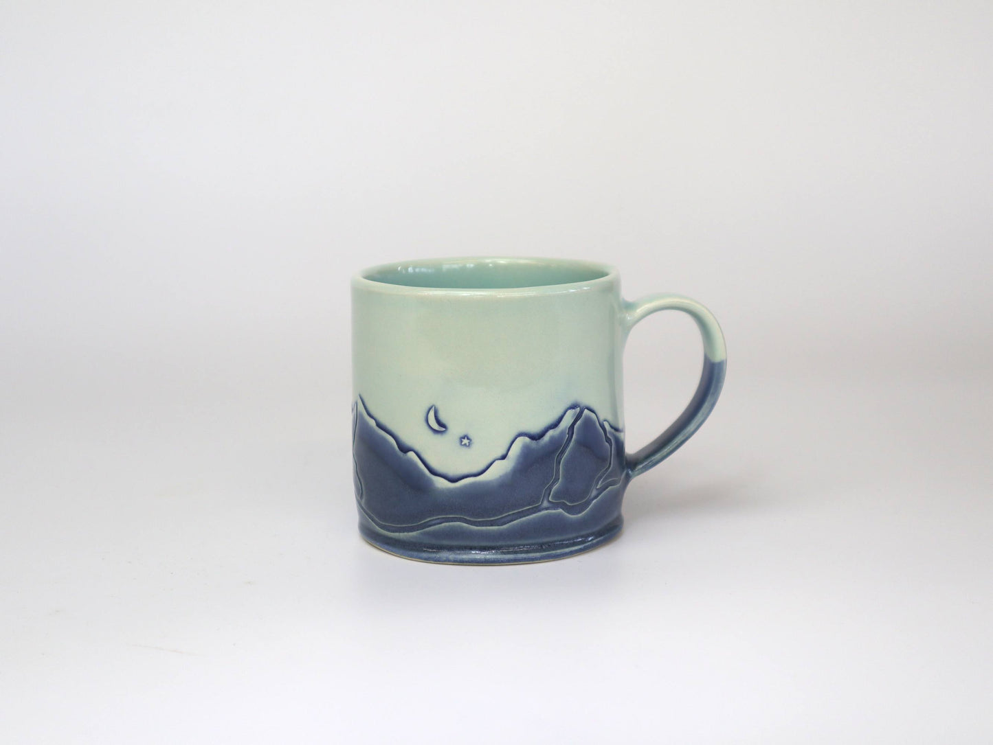 Close-up of the crescent moon and mountain design on a Handmade Mountain Range Mug.