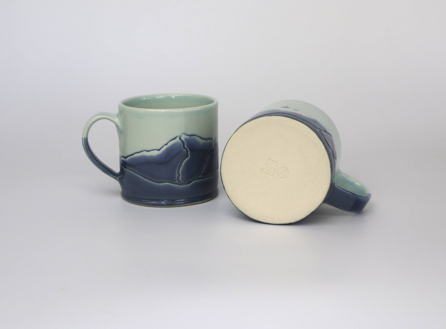 Set of two Handmade Coffee Mugs showcasing nature inspire designs.