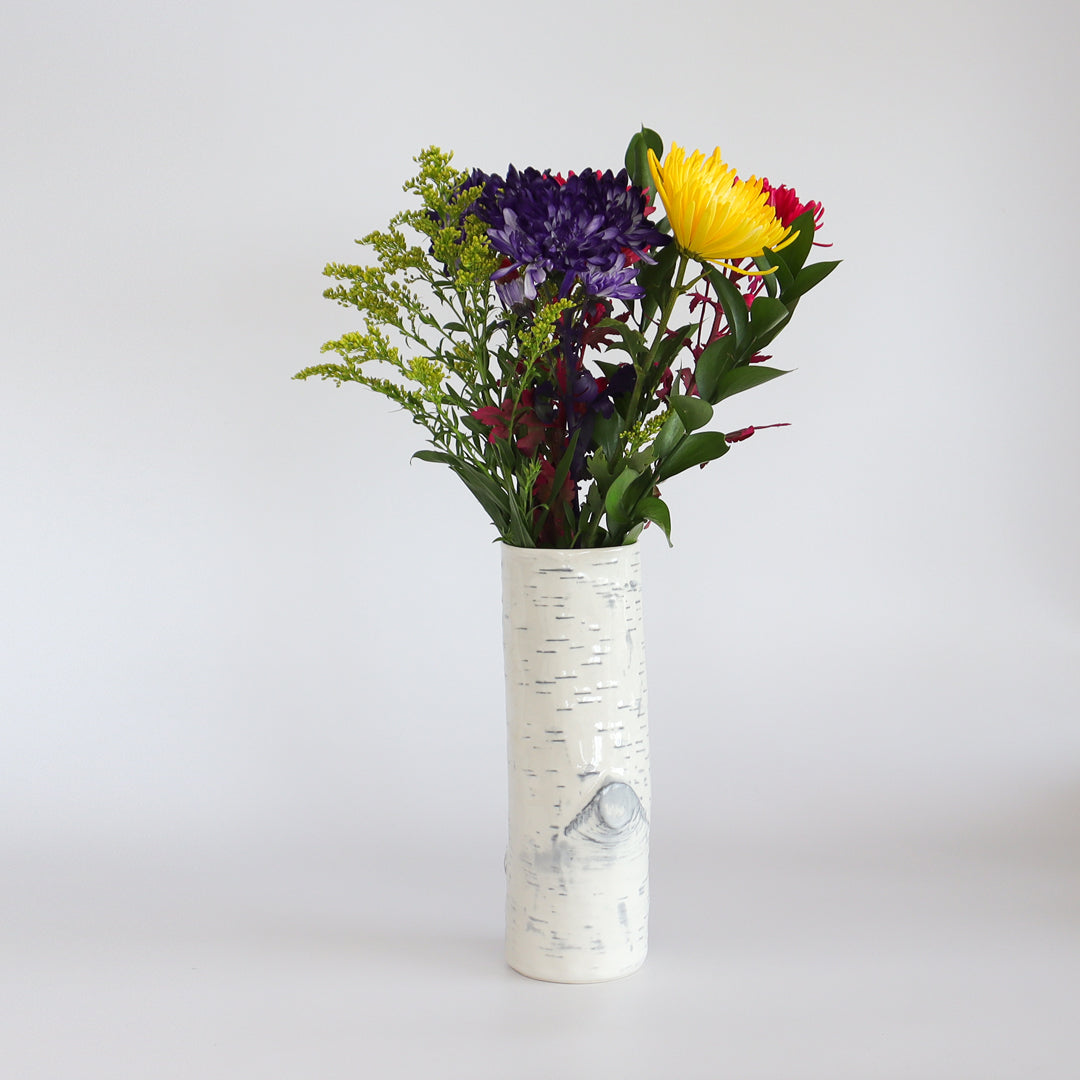 Close-up of the birch ceramic vase with a colorful floral arrangement.