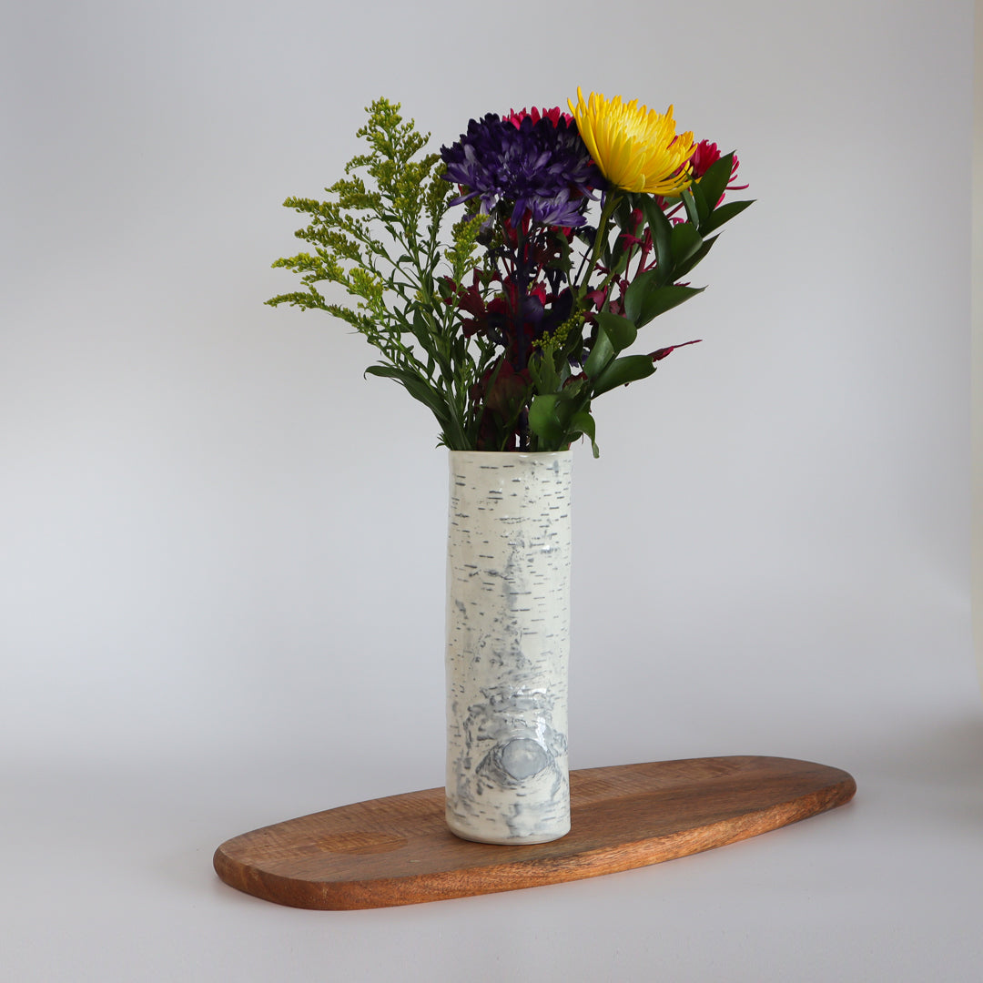 Birch ceramic vase adorned with fresh flowers, adding a natural touch to the decor.