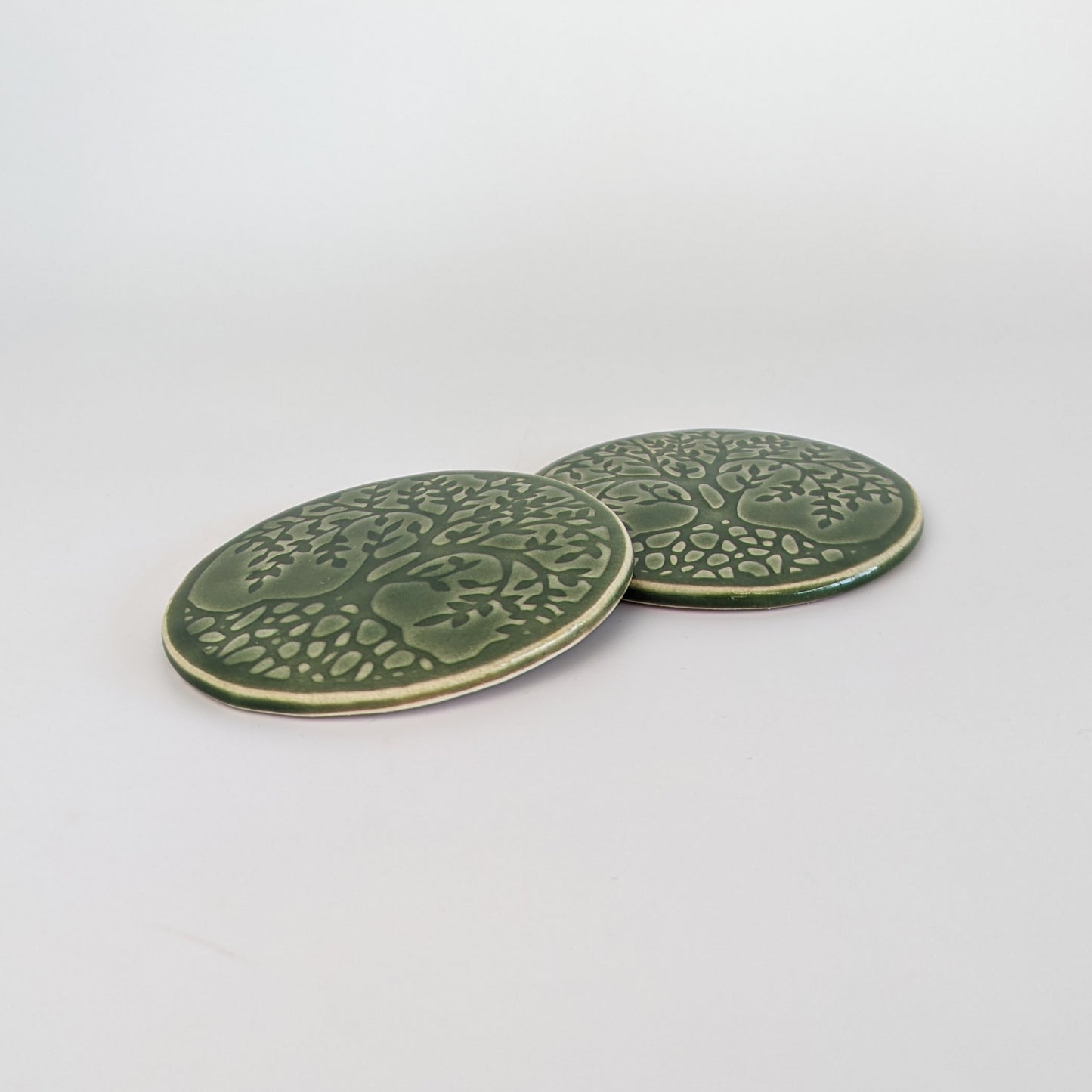 Set of two decorative coasters with a calming bottle green glaze.