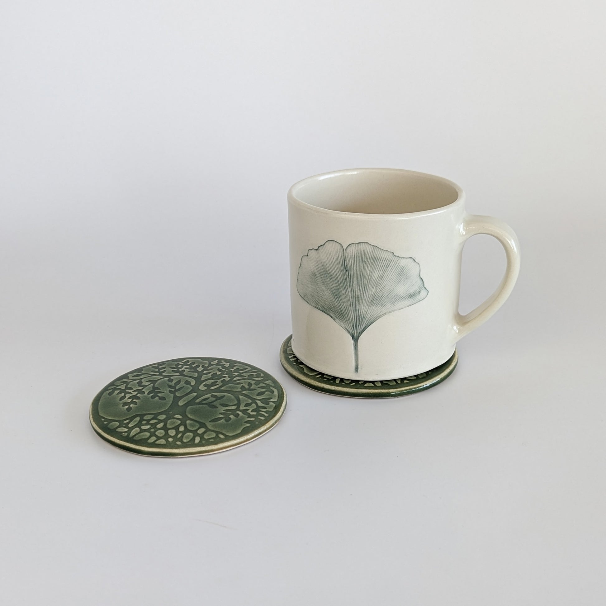 Ceramic coasters paired with a matching mug, showcasing the Gingko Leaf motif.