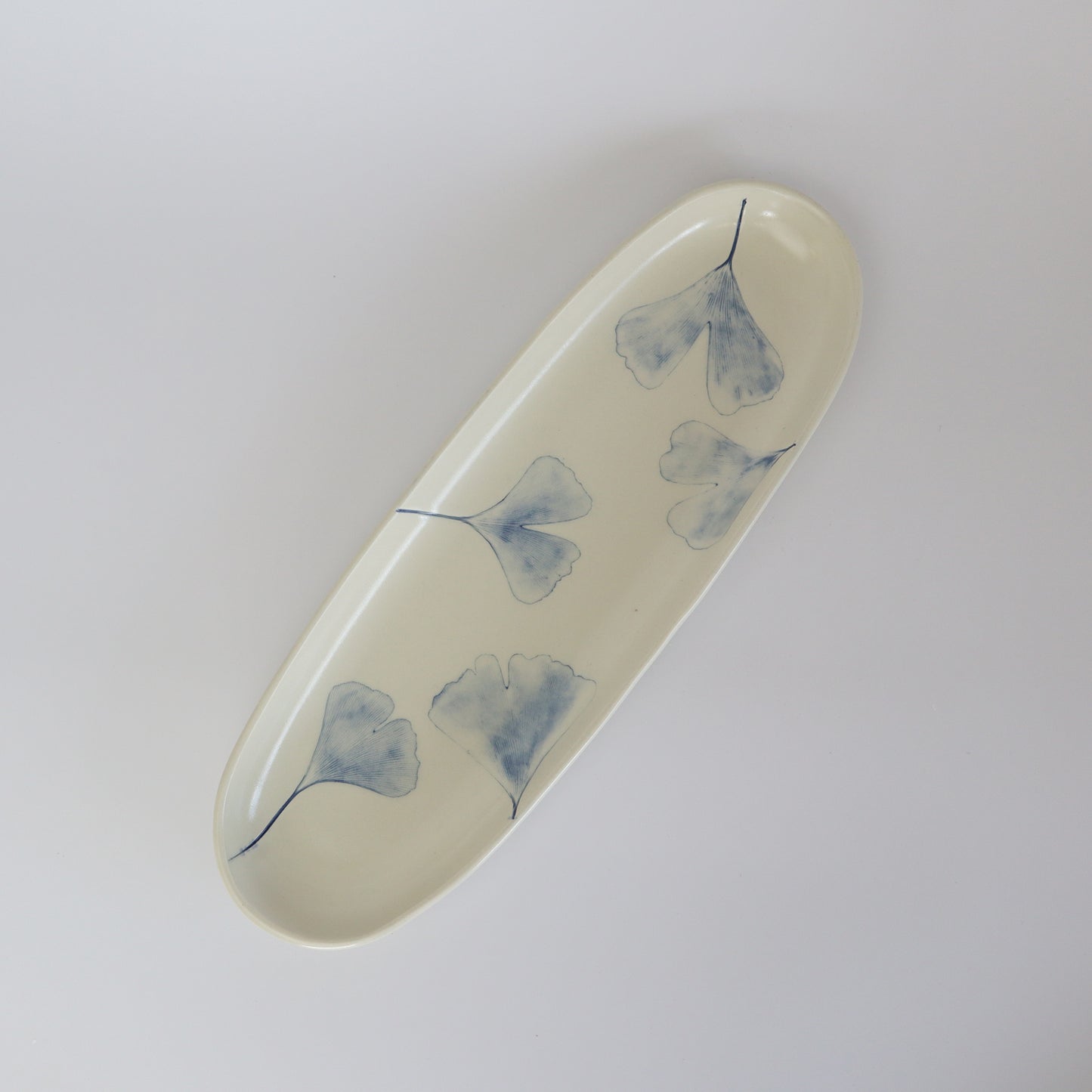 Elegant porcelain service plate adorned with a delicate Ginkgo Biloba leaf motif, perfect for special occasions.