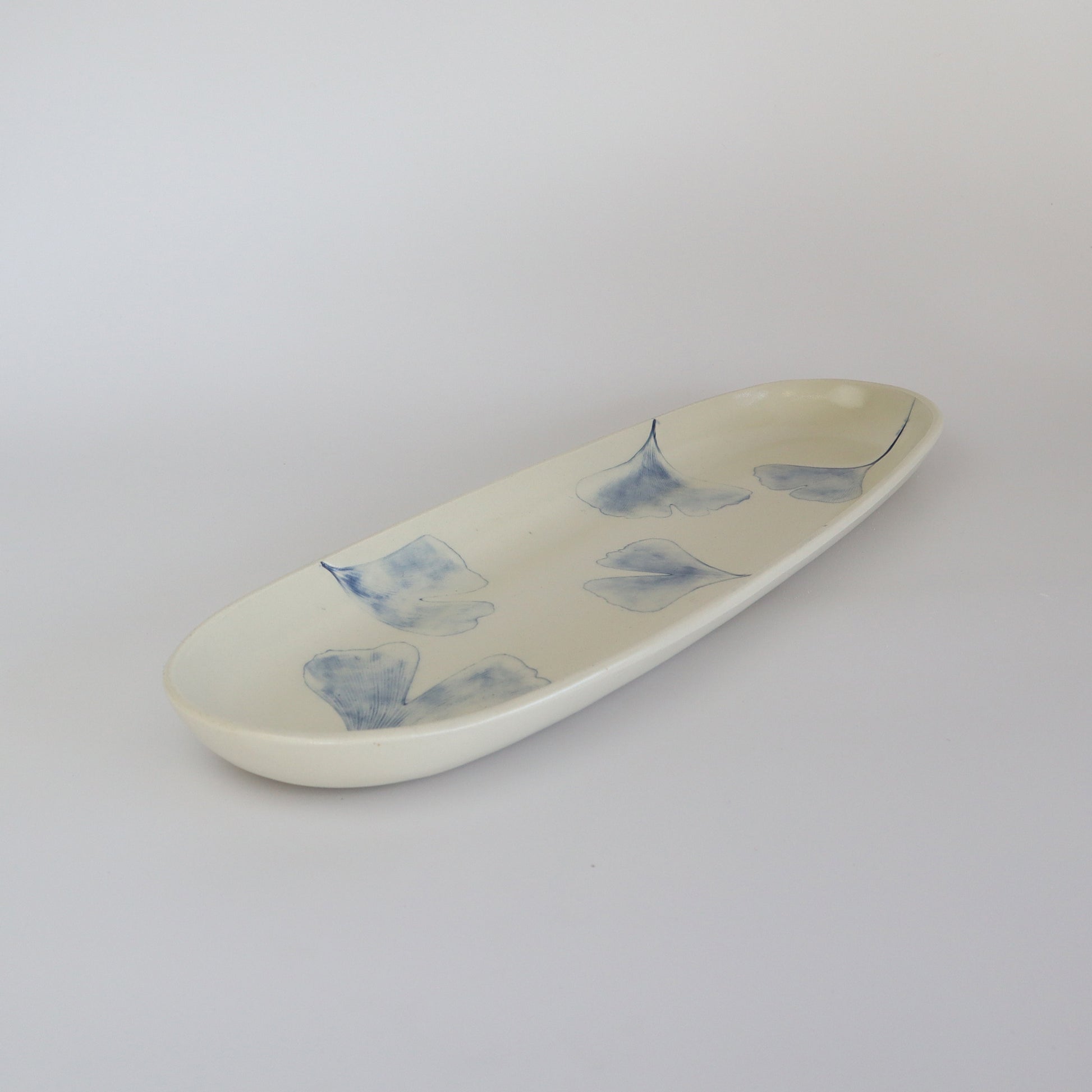 Ginkgo Biloba leaf design on a porcelain service plate in soothing blue tone, ideal for enhancing dining decor.